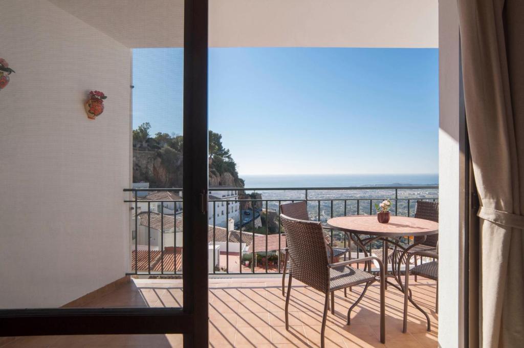米哈斯Apartment Vista de Pájaro的阳台配有桌子,享有海景。