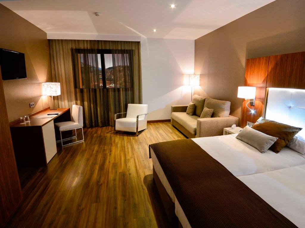 特鲁埃尔波坦尼克斯大酒店的酒店客房,配有一张床、一张桌子和椅子