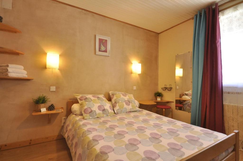 瓦卢伊斯l' Edelweiss B&B Chambre d'Hôtes的卧室配有一张床,墙上有两盏灯