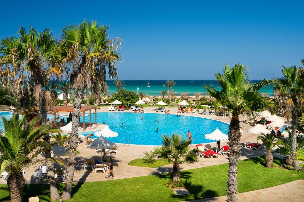乌姆苏克Iliade Aqua Park Djerba的享有棕榈树度假村泳池的顶部景致