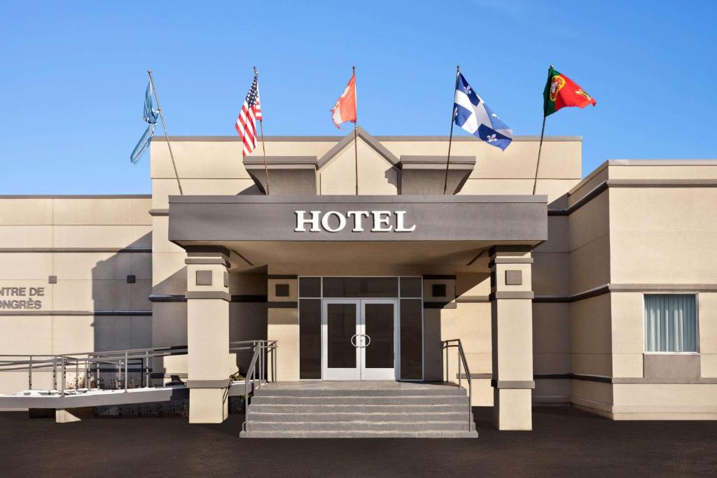 布兰维尔Hotel Days Inn Blainville & Centre de Conférence的大楼前有旗帜的酒店