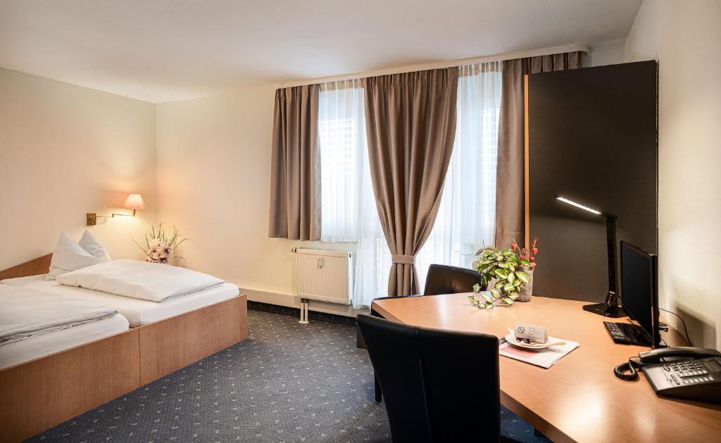 赖恩海姆苏尼贝尔旅馆的配有一张床和一张书桌的酒店客房
