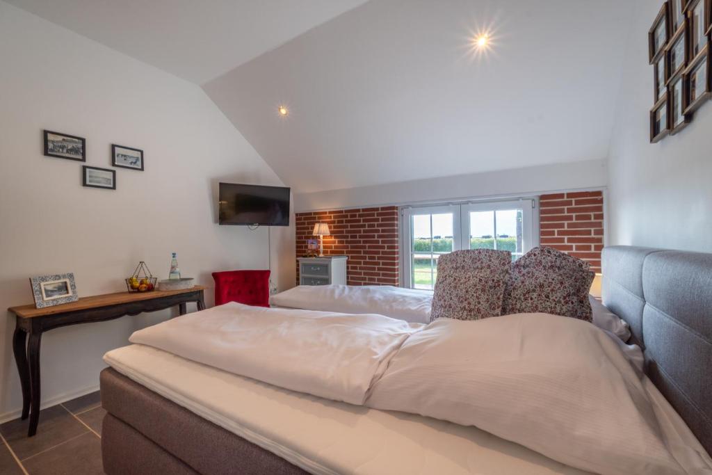 博尔库姆Insel-Land-Hotel Michaelsen的一间卧室设有一张大床和砖墙