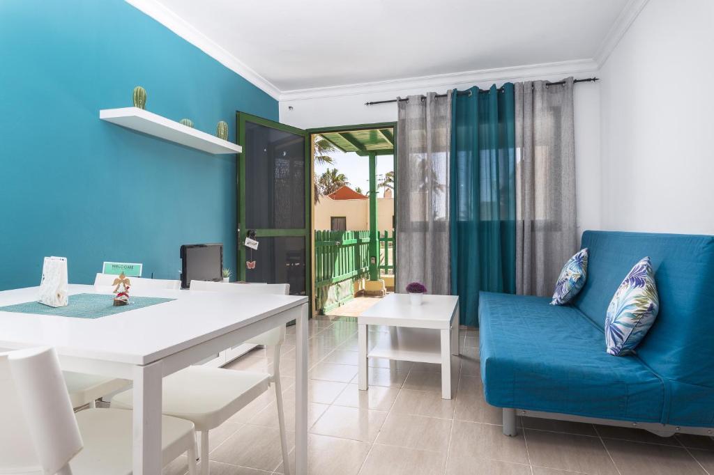 科斯塔卡玛8202 - Wifi Costa Calma Bungalow的客厅配有蓝色的沙发和桌子