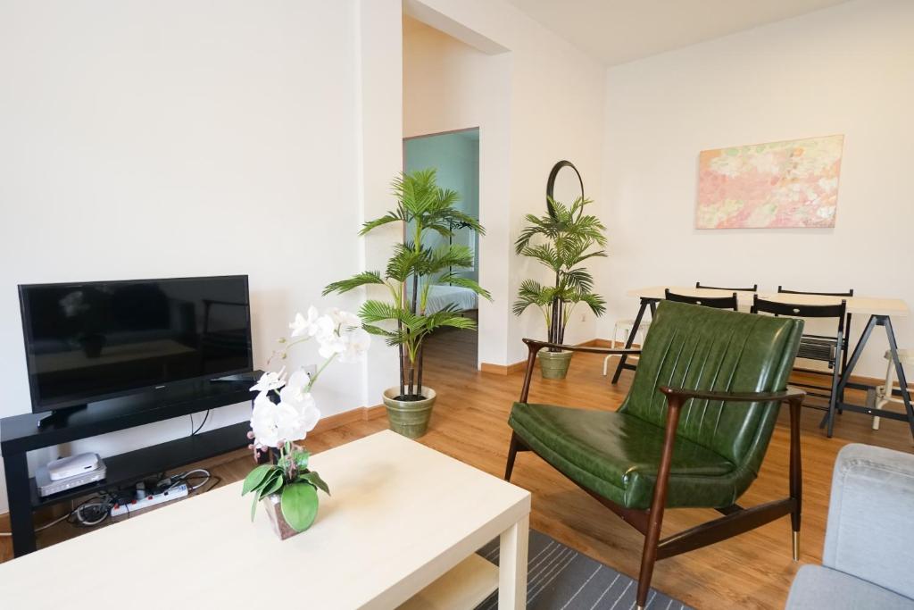 哥打京那巴鲁IKO homes的客厅配有电视和绿色椅子