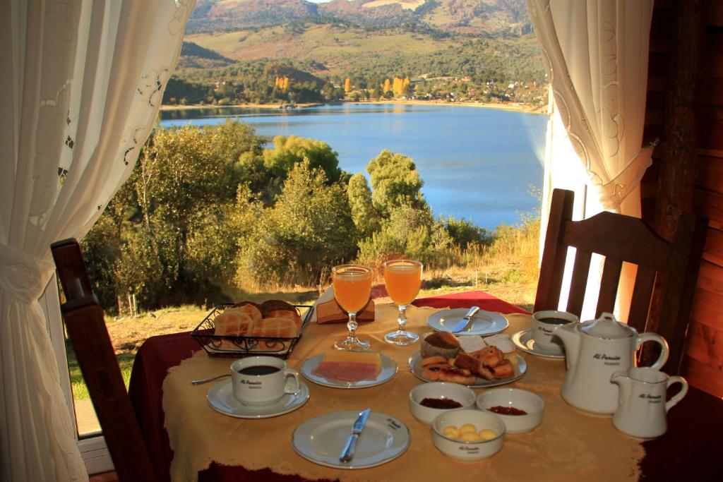 佩休尼亚镇帕拉伊索宾馆的一张带食物和饮料的桌子,享有湖景