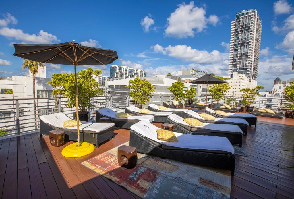 迈阿密海滩里维埃拉套房酒店的屋顶上的一排长椅和雨伞