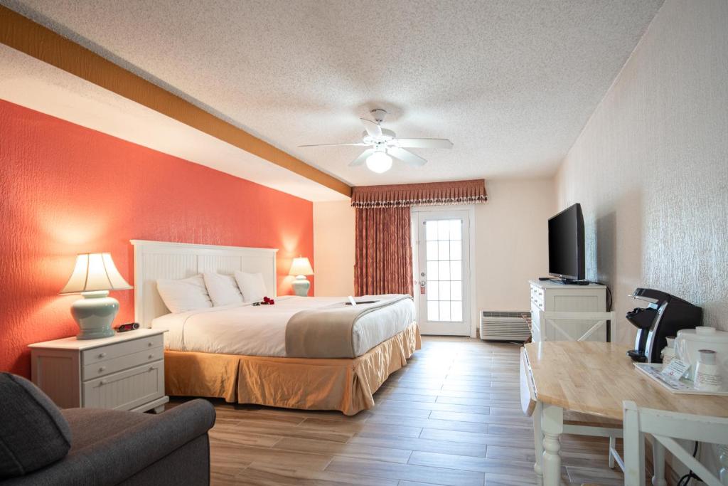 威尼斯Island Sun Inn & Suites - Venice, Florida Historic Downtown & Beach Getaway的一间卧室配有一张床、一台电视和一张沙发