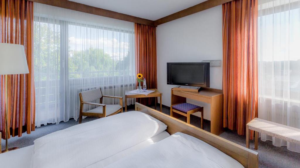 普海姆帕尔斯贝里酒店的酒店客房,配有床和电视