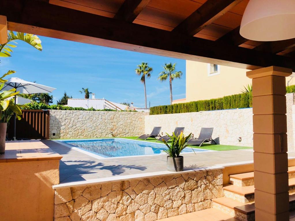卡拉罗曼蒂卡Villas2meet的一个带游泳池和房子的庭院