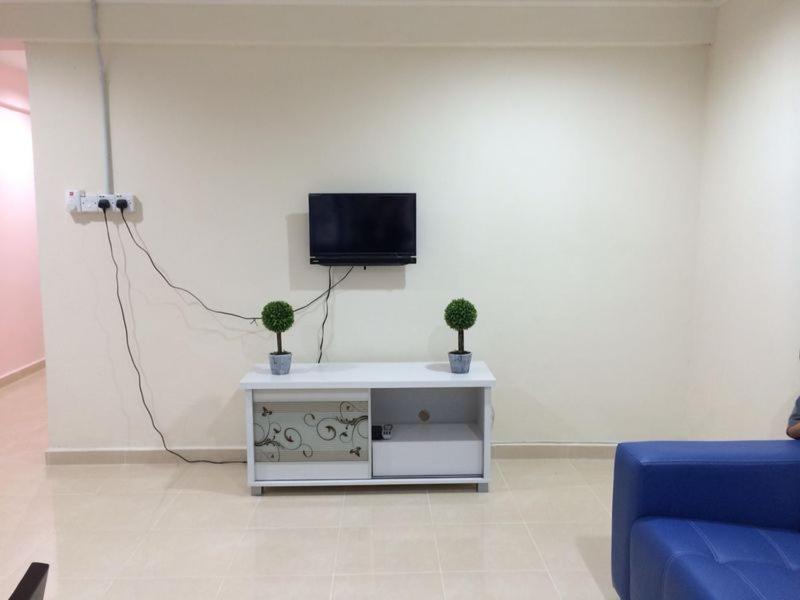 瓜埠langkawi homestay murah kawasan bandar的客厅配有电视和蓝色沙发。