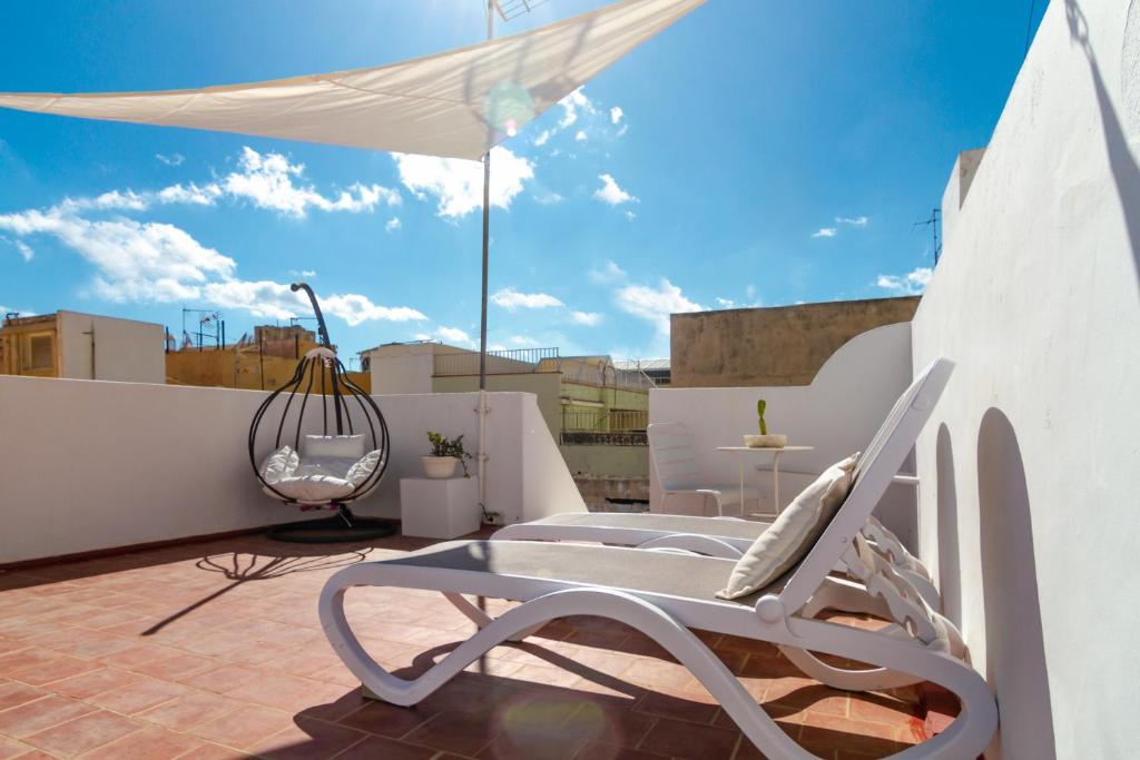 圣克鲁斯-德特内里费Casa Doña Carmela GuestHouse - Adults Only的屋顶上的白色椅子和雨伞