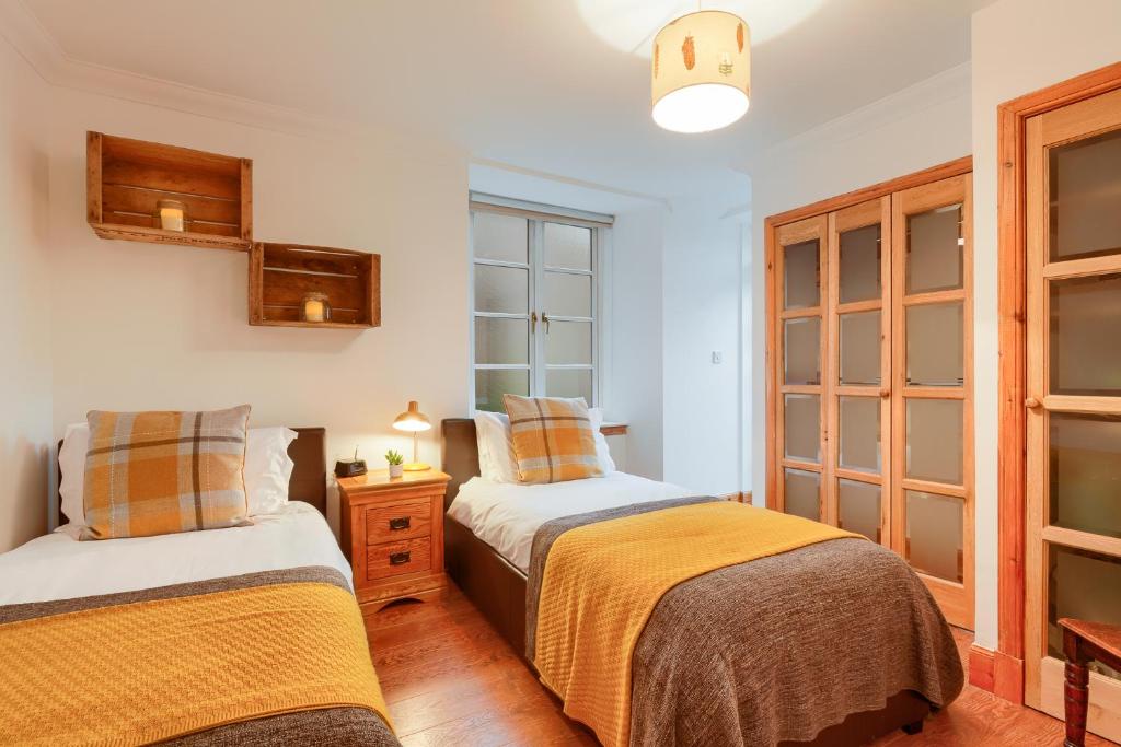 科姆里Dundas Flat, 1 bedroom, Comrie的一间卧室设有两张床和窗户。