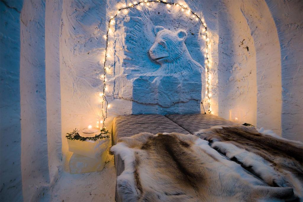 普哈圣山Lucky Ranch Snow Igloos的一间设有一张床铺的房间,配有熊雕像