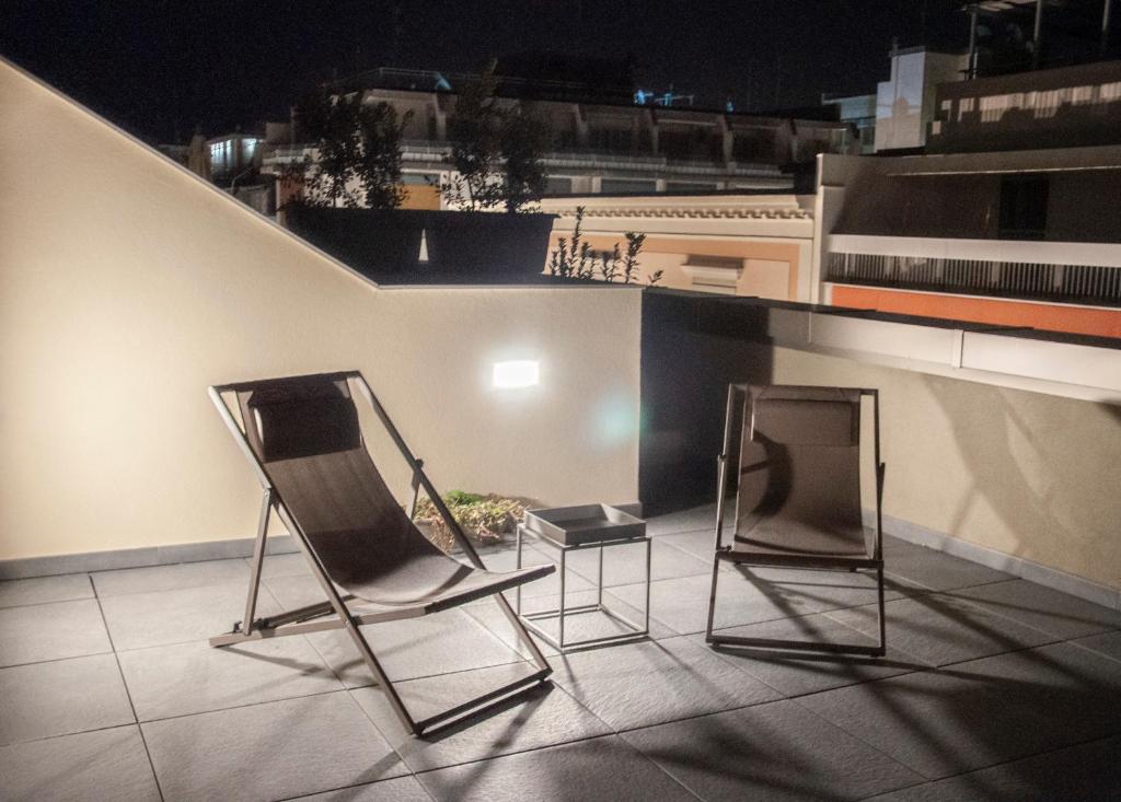 巴里NICOLA'S APARTMENTS的夜间屋顶设有两把椅子和一台电视机
