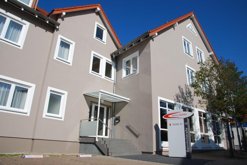 瓦尔多夫Walldorf Suites Boutique Hotel的前面有标志的白色建筑