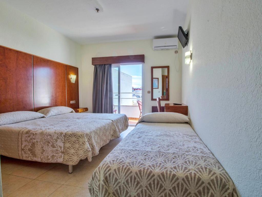 多列毛利诺斯Nch Hotel Torremolinos的酒店客房设有两张床和一个阳台。