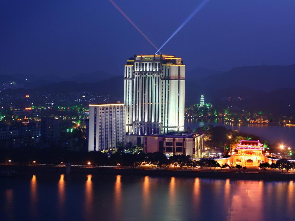 惠州惠州康帝国际酒店的一座城市在晚上点燃,有一座大建筑
