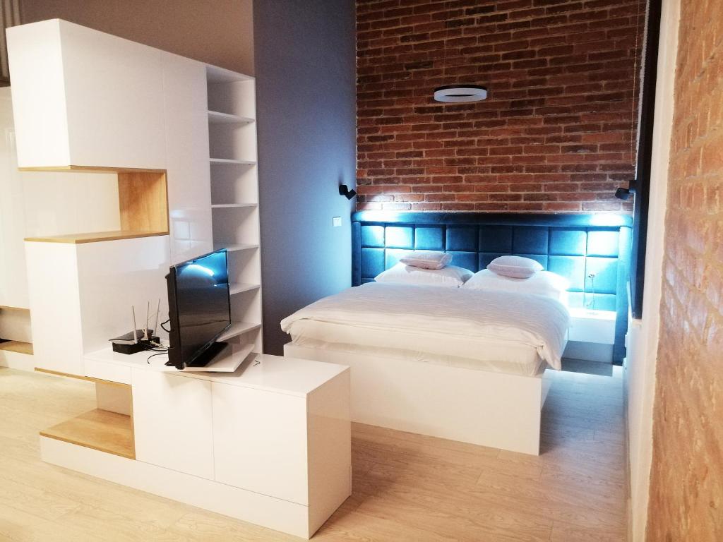 科希策Entrez Apartments 4 - City centre的一间卧室设有一张床和砖墙