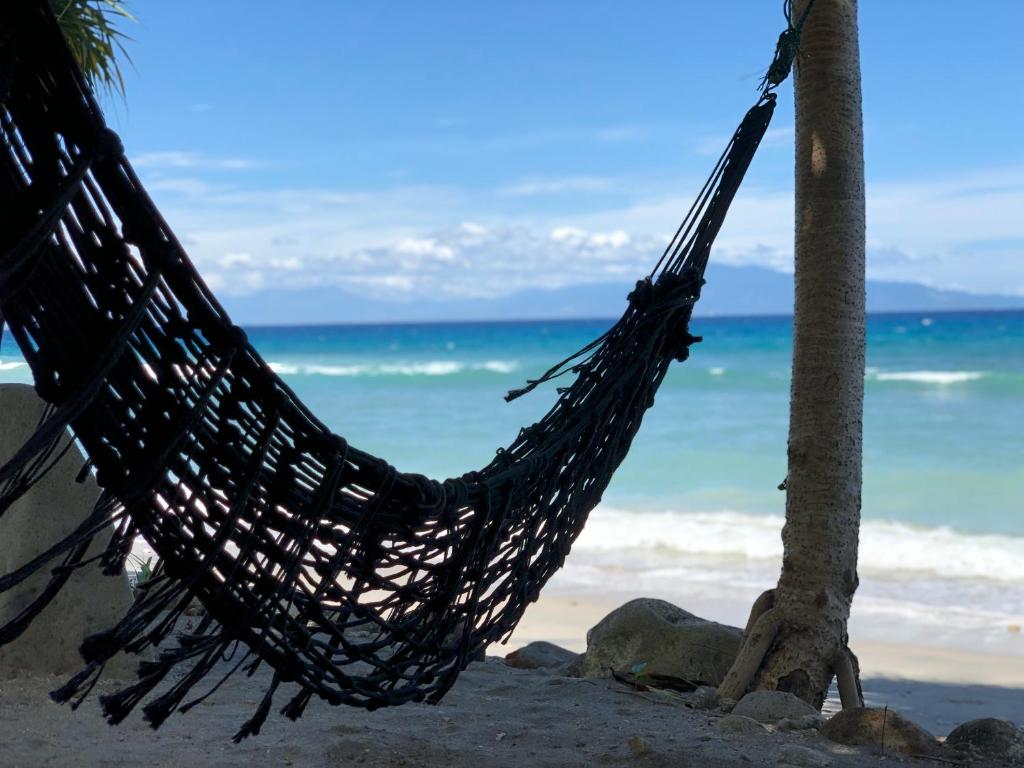 沙璜普劳韦天堂度假屋的海滩上棕榈树上的吊床