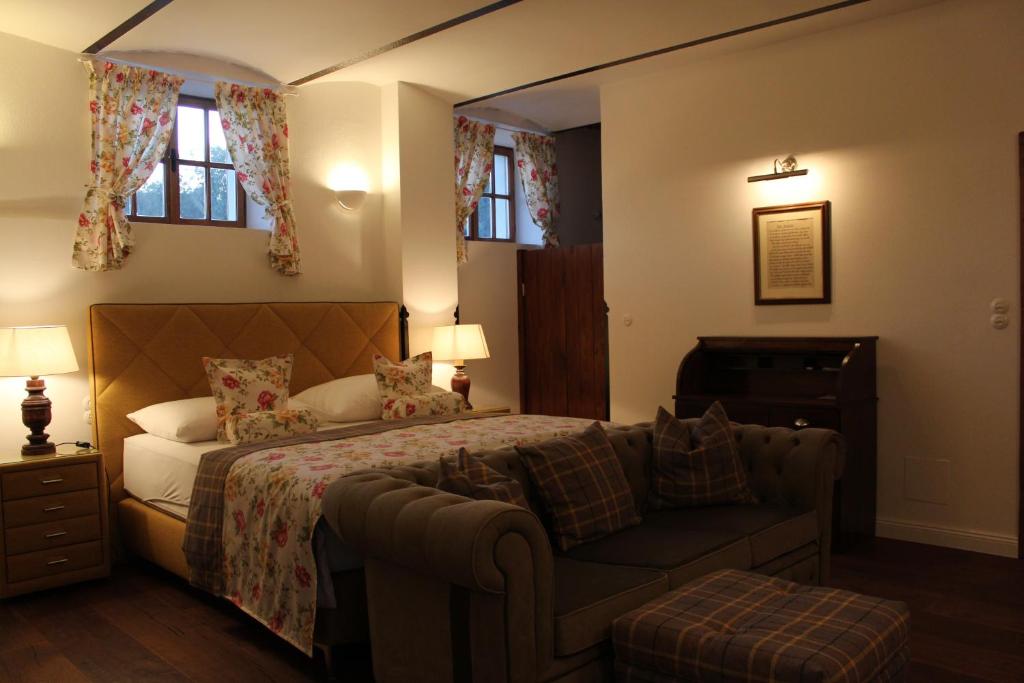 Sankt Anna am AigenBurgunderhof - Steiermark的一间卧室配有一张床、一张沙发和窗户。