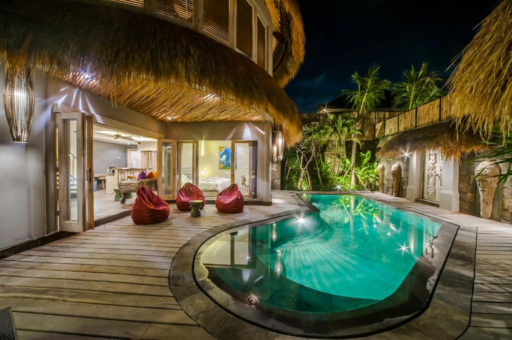 塞米亚克Luxury Villas Merci Resort 3BR Seminyak #1的夜间带游泳池的别墅