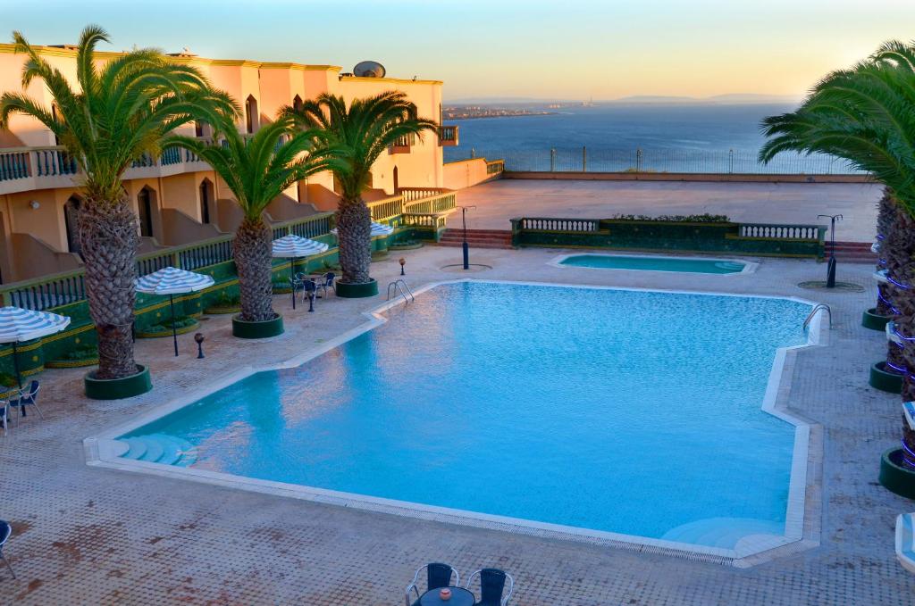 萨菲Hôtel Atlantique Panorama的棕榈树酒店游泳池的形象