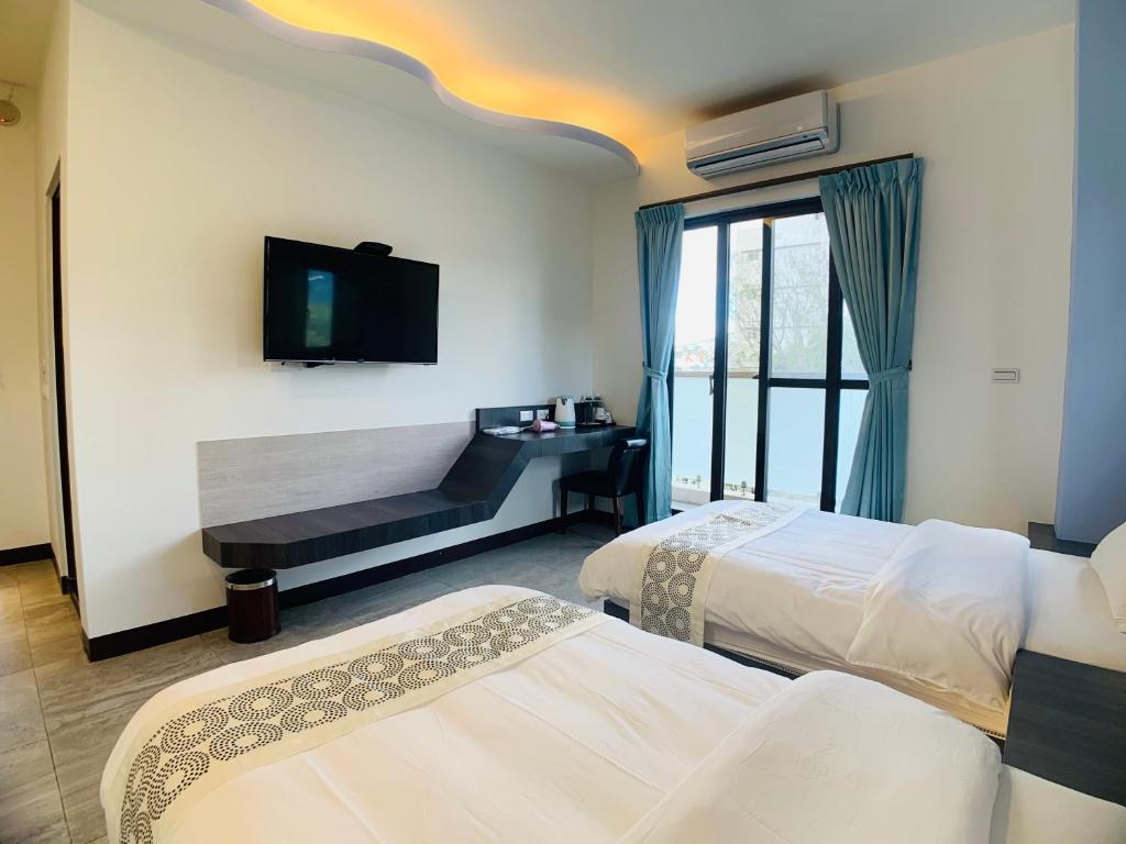 池上Xuyu Homestay的酒店客房设有两张床和一台平面电视。