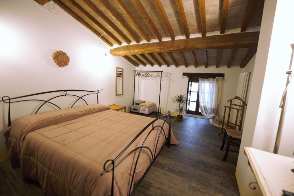 皮恩扎Camere La Carbonaia的一间卧室配有一张床,铺有木地板