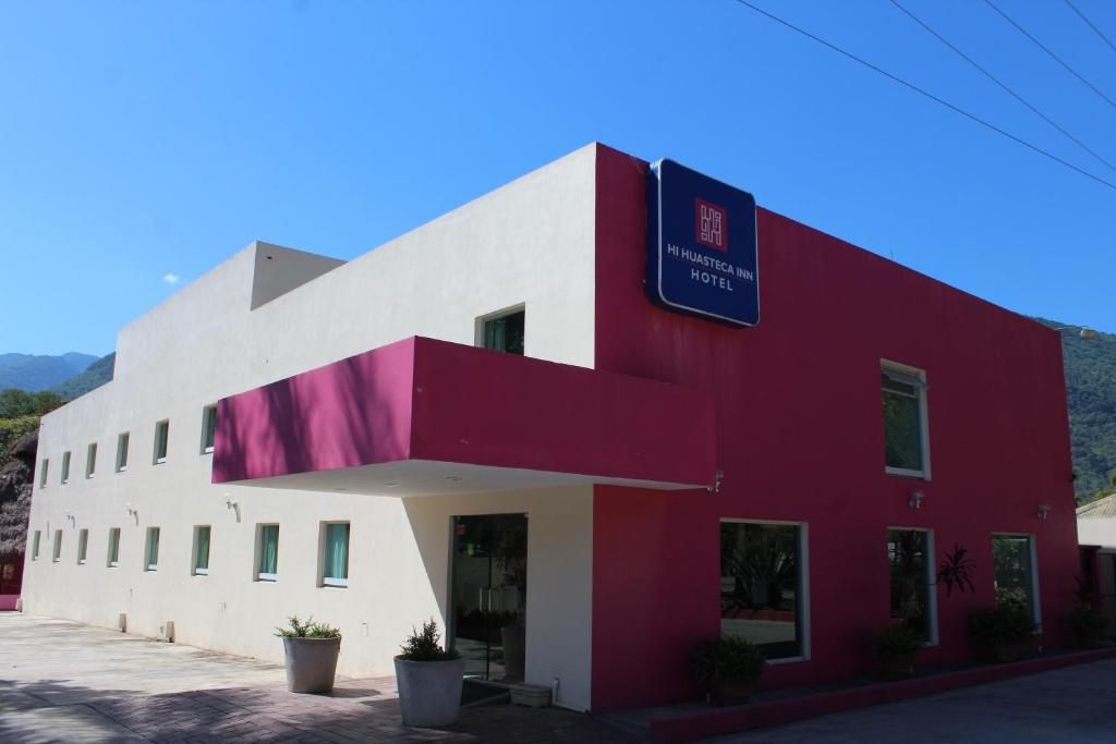 MatlapaHI Huasteca Inn Hotel的一座红色和白色的建筑,上面有标志