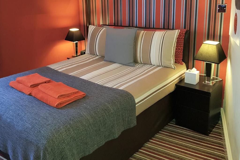 诺丁汉城中心罗宾7号酒店的一间卧室配有一张带橙色毛巾的床