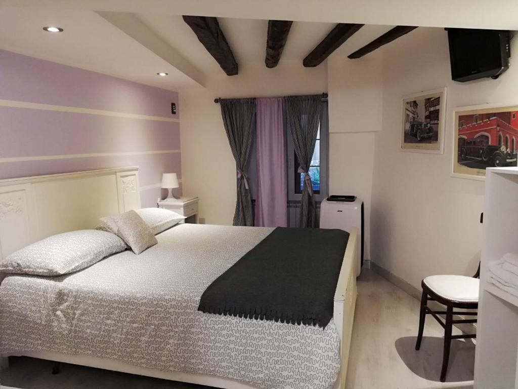 卡尔塔吉罗Palazzo Sant'Elia的一间卧室设有一张大床和紫色的墙壁