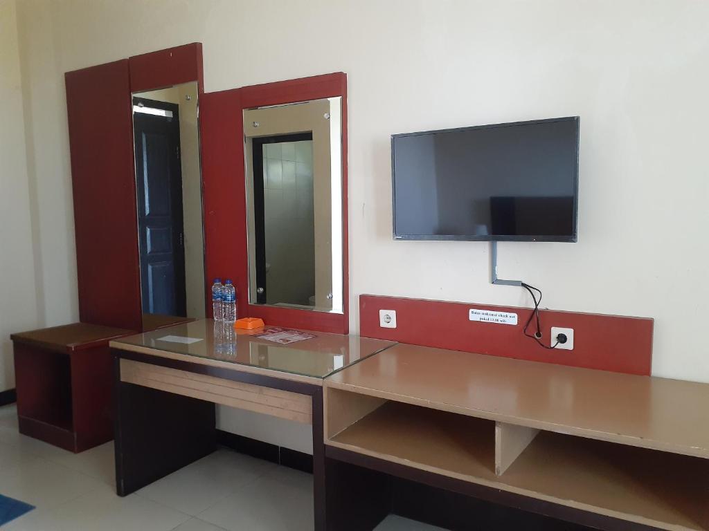 巴图拉登Surya Hotel & Resort的客房设有书桌和墙上的电视