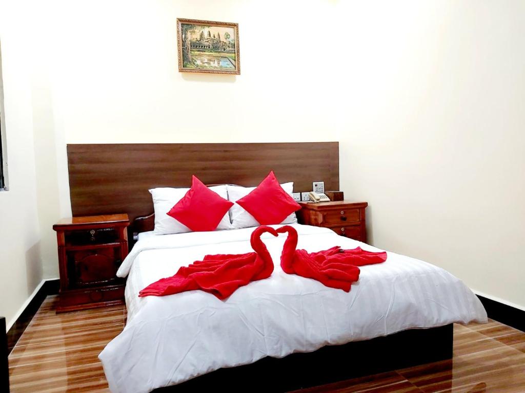 金边首都一号旅馆的两个红色的天鹅坐在床上