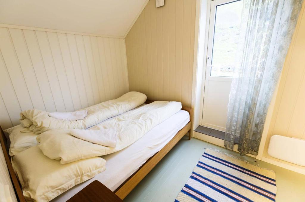 SørværElfridastua的窗户客房内的小床