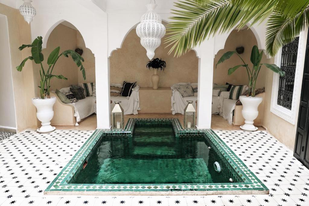 马拉喀什Riad SHIRAZ的客厅,位于房子的中间,设有游泳池
