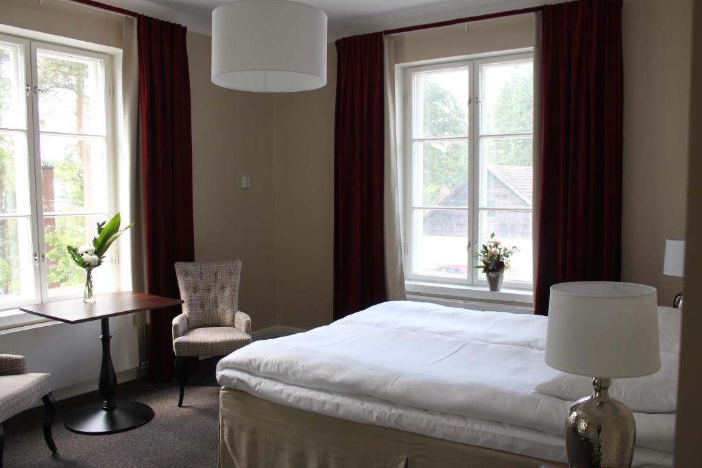 MäntsäläHotelli Kartanon Meijeri的一间卧室配有一张床、一把椅子和窗户。