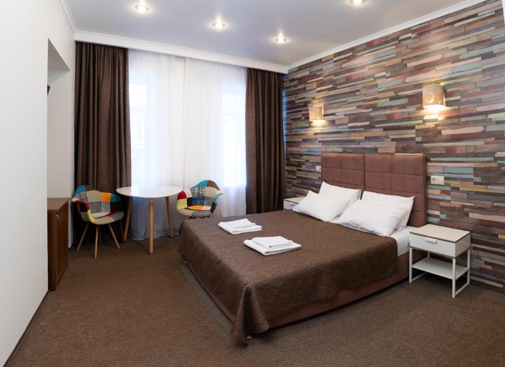 圣彼得堡Guest House Ligovsky的酒店客房带一张床、一张桌子和椅子
