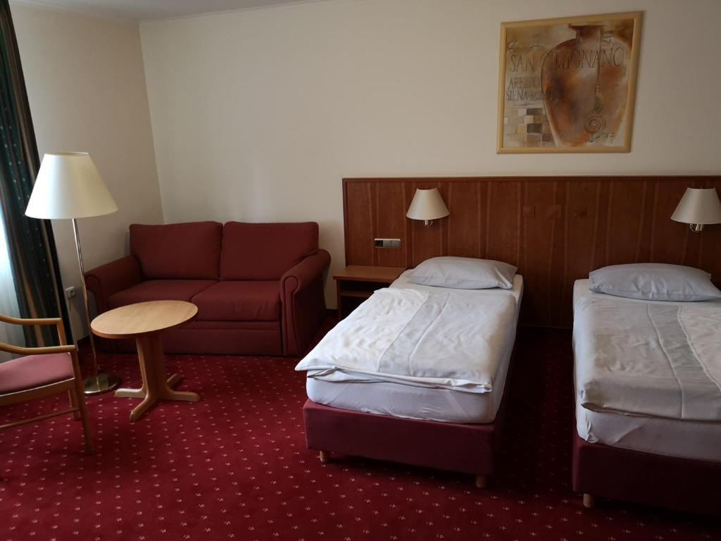 奥尔珀Hotel & Ristorante Il Duomo的酒店客房,设有两张床和一张沙发