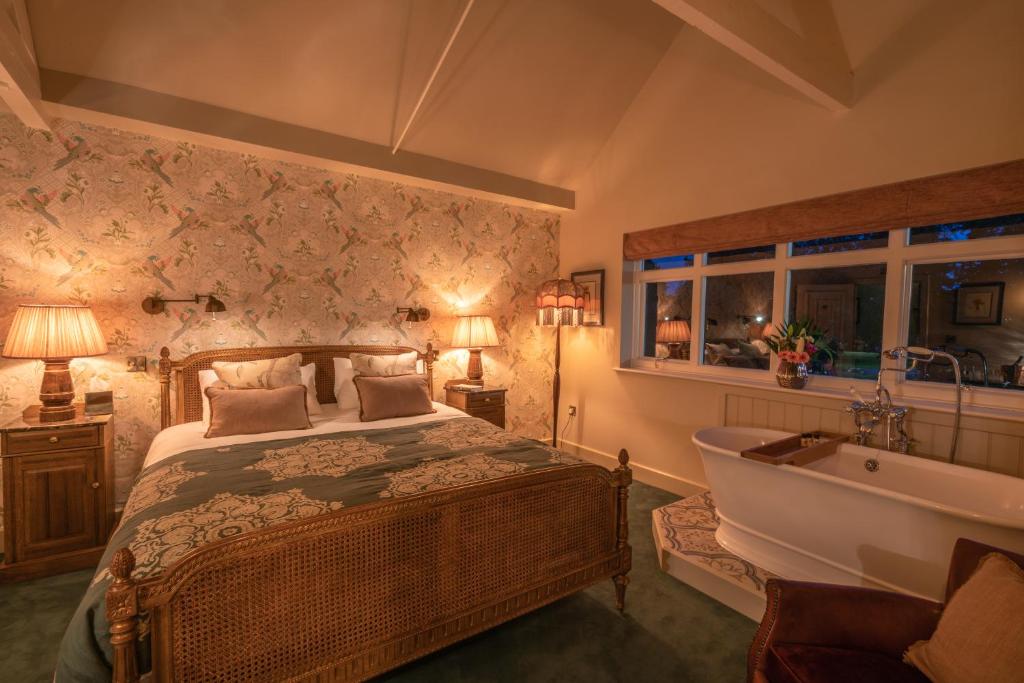 贝德福德Albero Bedrooms的一间卧室配有一张床、一个浴缸和一个水槽