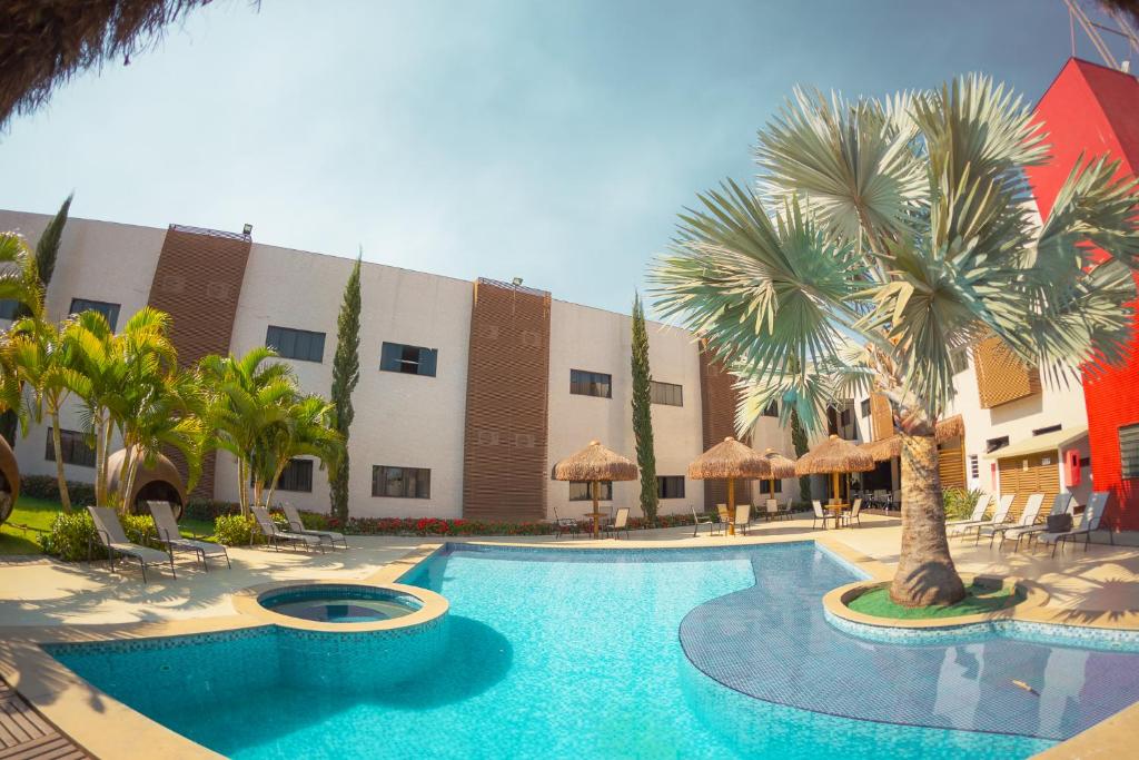 福莫萨Sofisticatto Park Hotel的一座楼前棕榈树游泳池