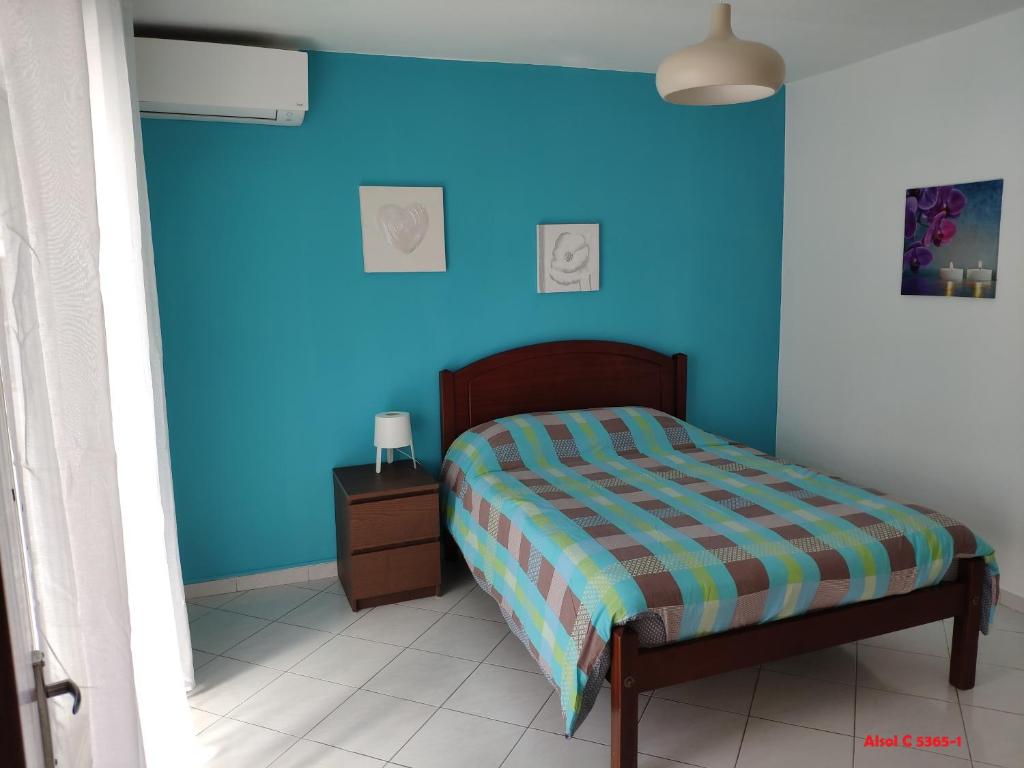 奎特里拉Alsol C 5365-1的一间卧室配有一张蓝色墙壁的床