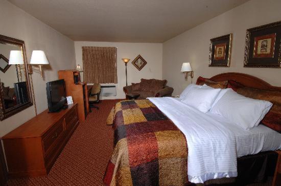 布兰森All American Inn & Suites Branson的酒店客房,配有床和电视