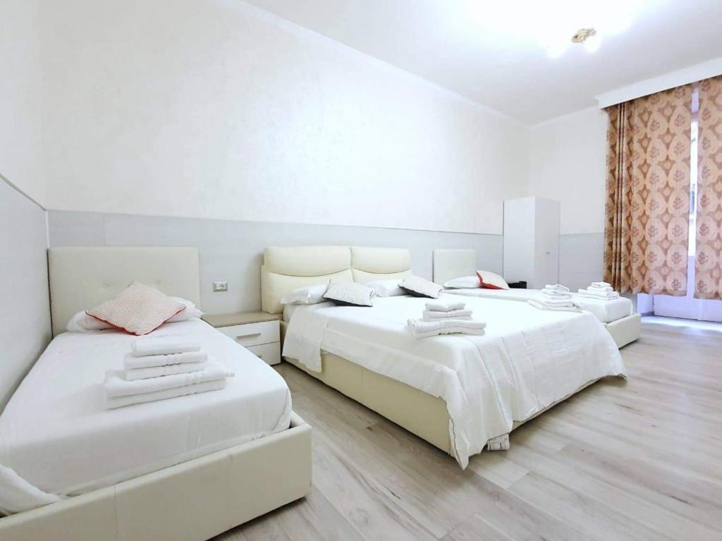 罗马Oscar suite home的卧室设有两张床,拥有白色的墙壁和木地板