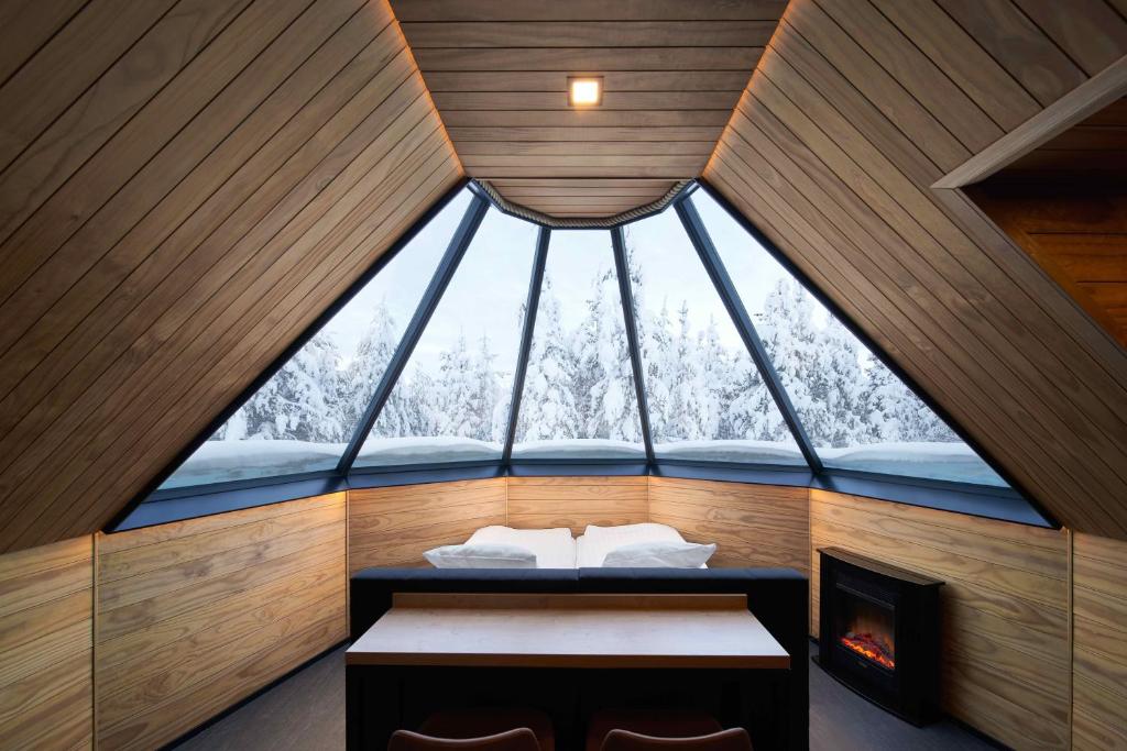 列维Northern Lights Village Levi的配有一张床和壁炉的客房内的大窗户
