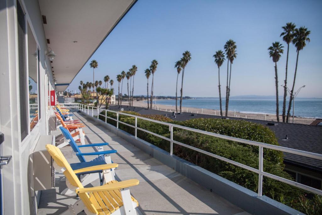 圣克鲁兹海滩街套房酒店的俯瞰海滩的阳台上摆放着一排椅子