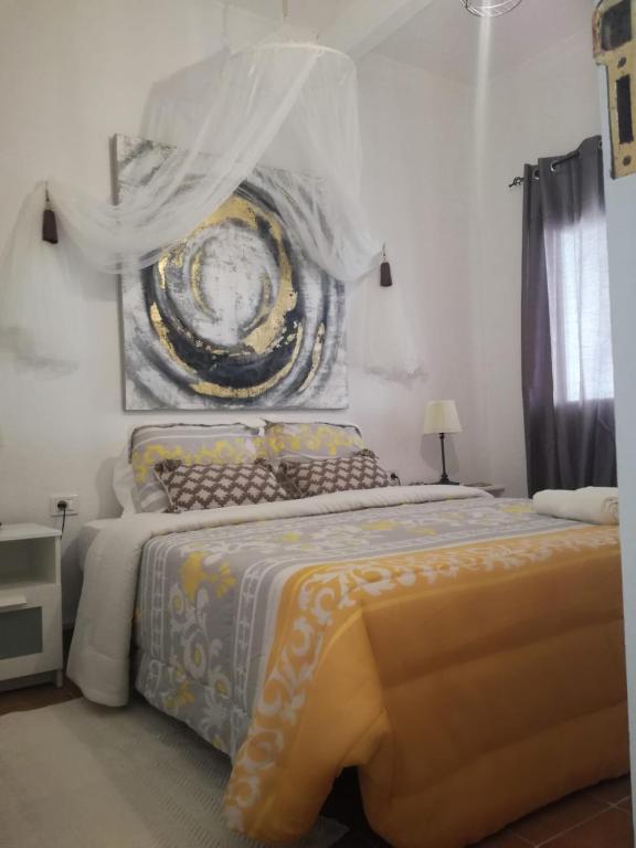 洛斯·亚诺斯·德·阿里丹Townhouse Los Llanos de Aridane, La Palma的一间卧室配有一张大床,墙上挂着一幅大画