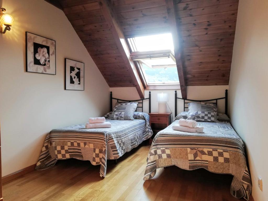 普拉德埃米塔Apartament Ca de Gallisca的阁楼上的卧室配有两张床