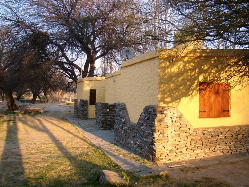 圣玛利亚Cabañas Achalay的树旁的石墙建筑