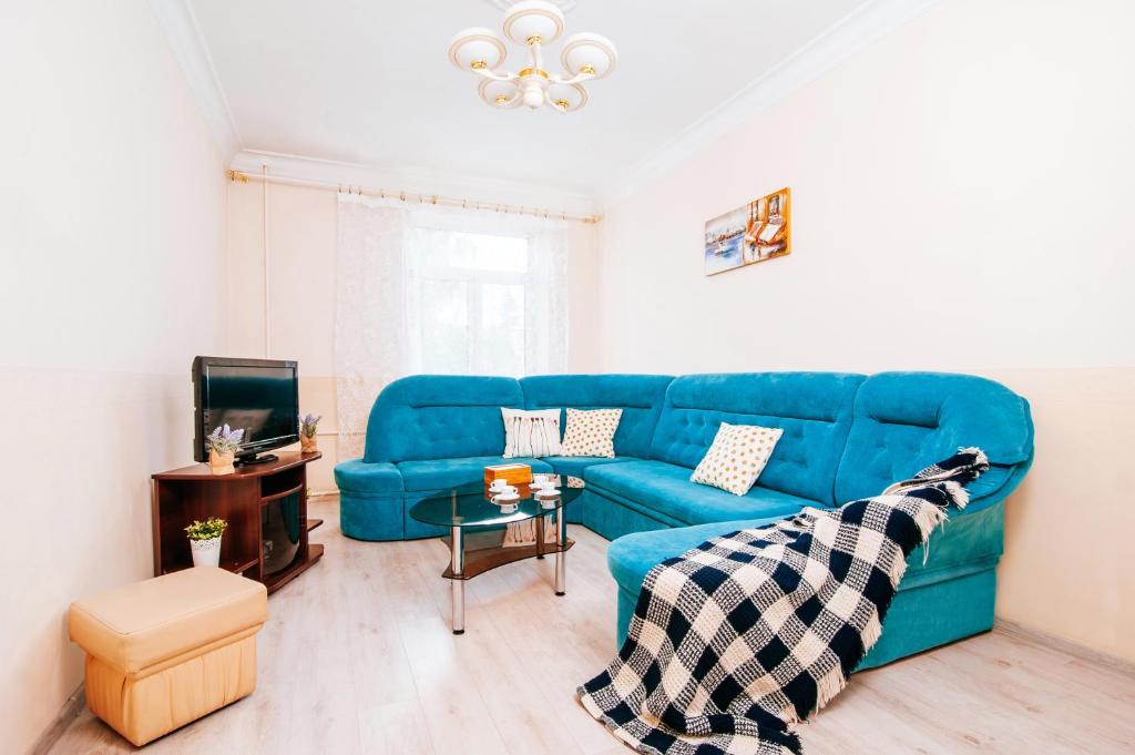 明斯克33 Apartments的客厅配有蓝色的沙发和桌子